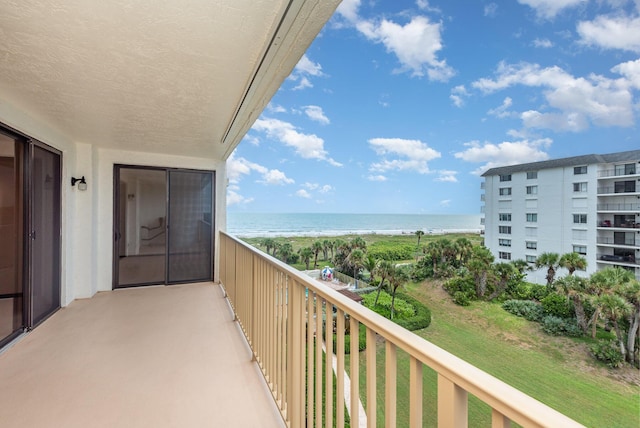 balcony featuring a water view and a view of the beach