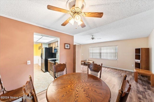 dining area featuring ceiling fan, crown molding, light hardwood / wood-style floors, and a textured ceiling