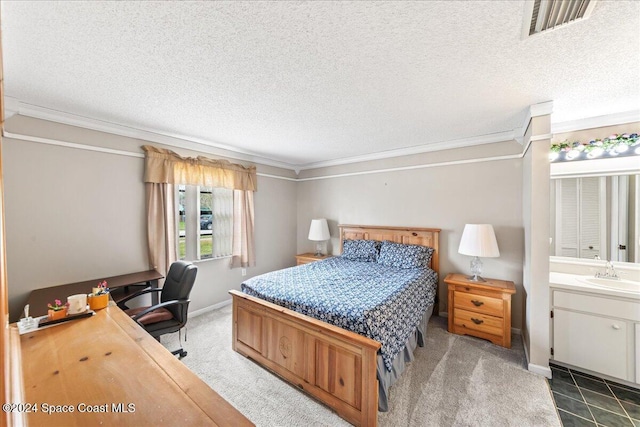 carpeted bedroom with ensuite bath, crown molding, sink, and a textured ceiling