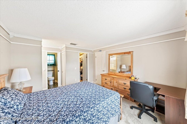 carpeted bedroom featuring ornamental molding, a textured ceiling, and ensuite bath