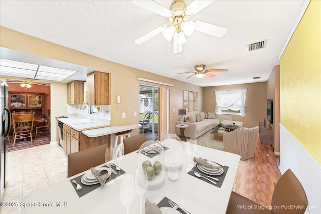 dining space with a textured ceiling, a healthy amount of sunlight, and sink