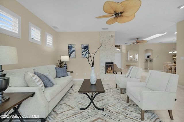 living room featuring a fireplace and ceiling fan