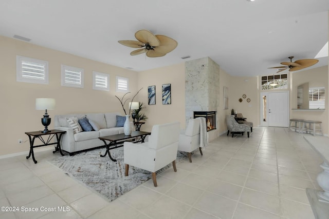 tiled living room featuring ceiling fan and a fireplace