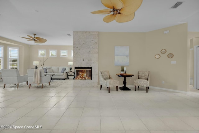 interior space featuring ceiling fan, light tile patterned floors, and a high end fireplace