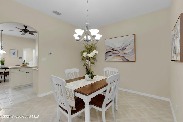 tiled dining space featuring ceiling fan with notable chandelier