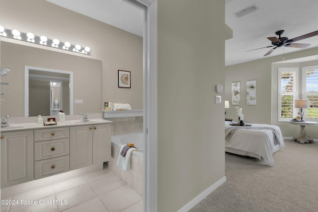 bathroom featuring ceiling fan, tile patterned floors, vanity, and a relaxing tiled tub