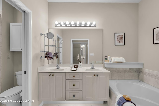 bathroom featuring vanity, tiled bath, and toilet