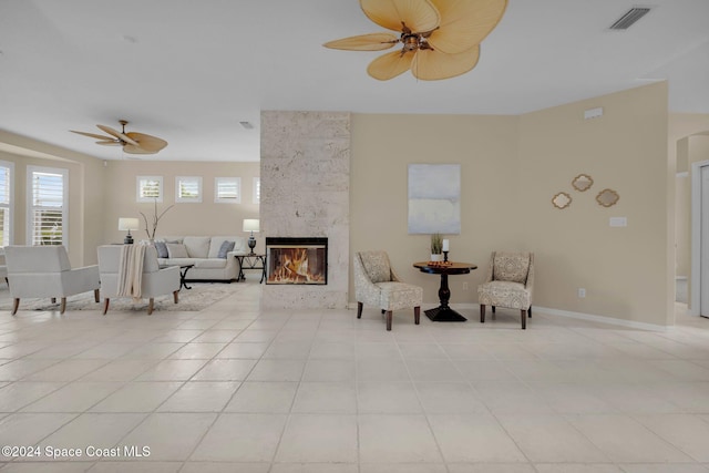 interior space featuring ceiling fan, a premium fireplace, and light tile patterned floors