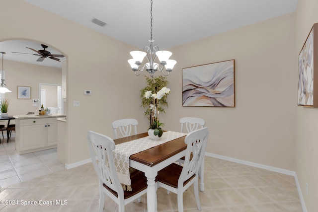 tiled dining space with ceiling fan with notable chandelier