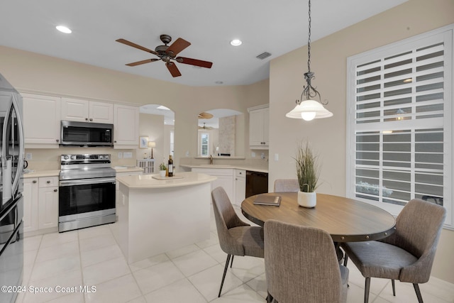 kitchen featuring white cabinetry, ceiling fan, appliances with stainless steel finishes, and hanging light fixtures