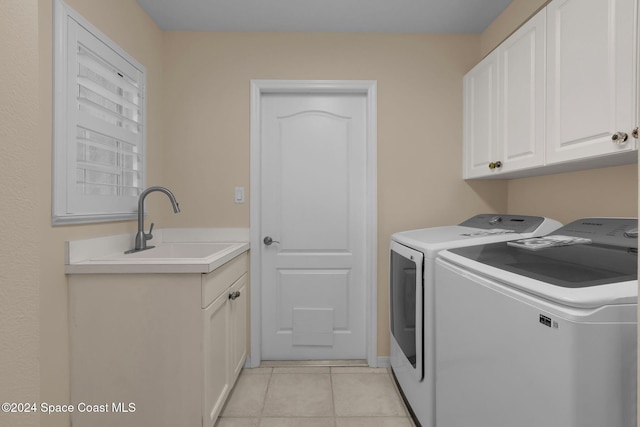 laundry room featuring cabinets, washer and clothes dryer, sink, and light tile patterned floors