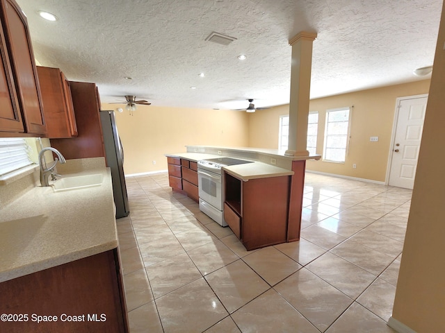 kitchen with ceiling fan, white electric stove, stainless steel refrigerator, and decorative columns