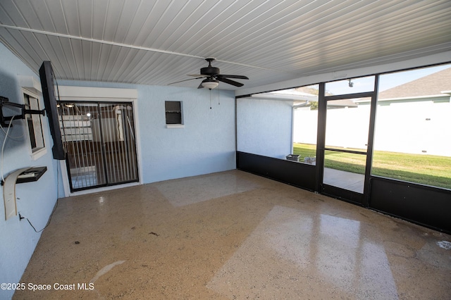 unfurnished sunroom with ceiling fan