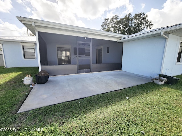 rear view of property with a sunroom, a patio area, and a yard