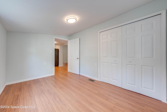 unfurnished bedroom featuring a closet and light wood-type flooring