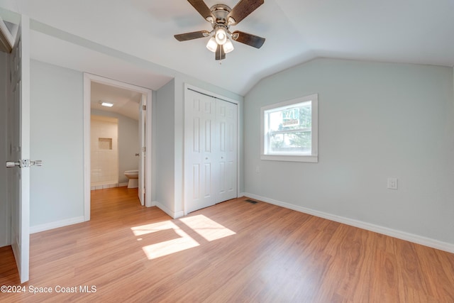 unfurnished bedroom featuring ceiling fan, a closet, light hardwood / wood-style floors, and vaulted ceiling