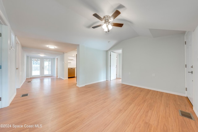 unfurnished living room featuring ceiling fan, light hardwood / wood-style floors, vaulted ceiling, and french doors