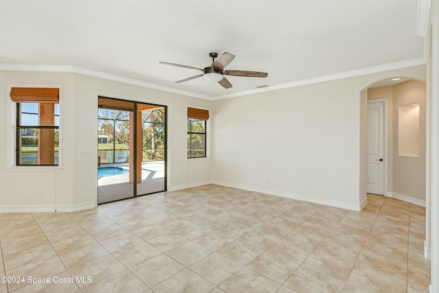 empty room featuring ceiling fan, crown molding, and light tile patterned floors