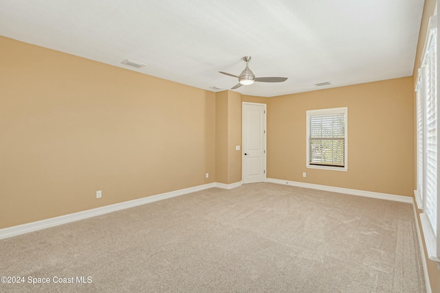 unfurnished room with ceiling fan and light colored carpet