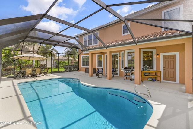 view of pool with a patio and glass enclosure