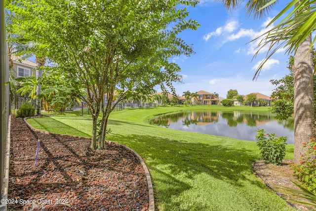 view of home's community featuring a lawn and a water view