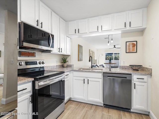 kitchen featuring sink, ceiling fan, light stone counters, white cabinetry, and stainless steel appliances