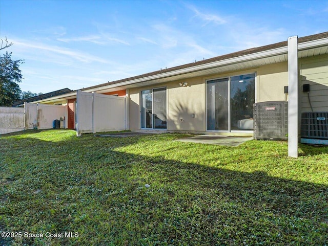 back of house with a lawn and central AC unit