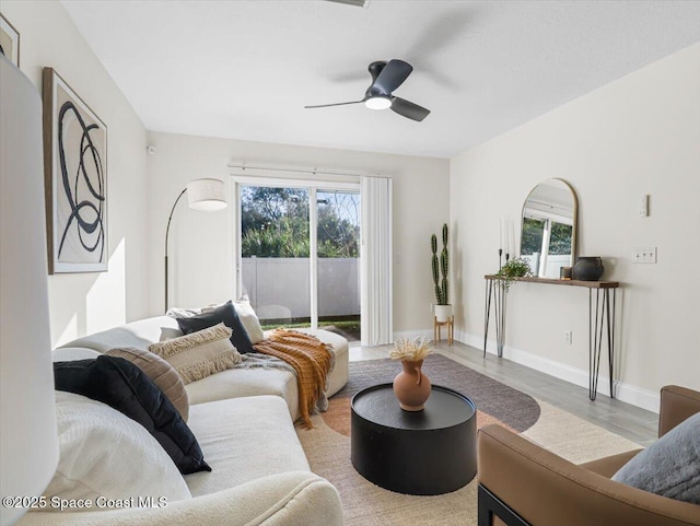 living room with ceiling fan, wood-type flooring, and a wealth of natural light