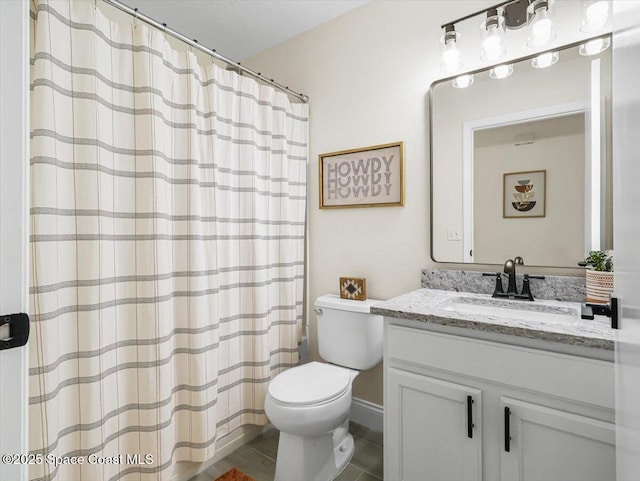 bathroom with tile patterned flooring, vanity, and toilet