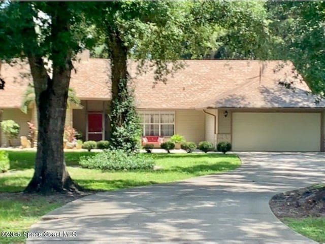 view of front of property with a garage and a front lawn