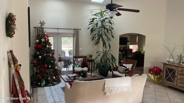 living room featuring ceiling fan, light tile patterned floors, french doors, and a skylight