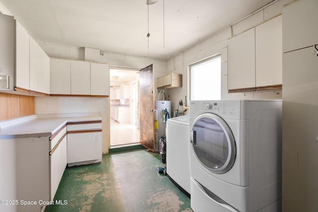 clothes washing area with cabinets, separate washer and dryer, and water heater