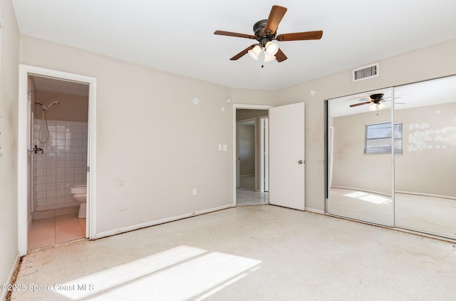 unfurnished bedroom featuring ensuite bath, ceiling fan, and a closet