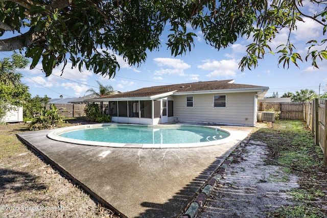 view of swimming pool with central AC and a sunroom