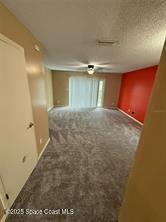 spare room with carpet flooring and a textured ceiling