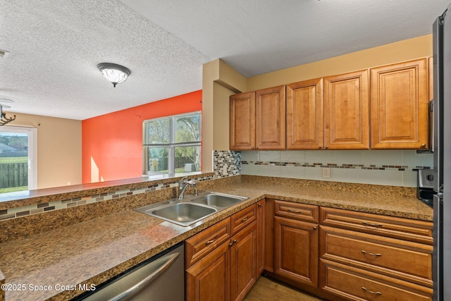 kitchen with kitchen peninsula, sink, decorative backsplash, and a wealth of natural light