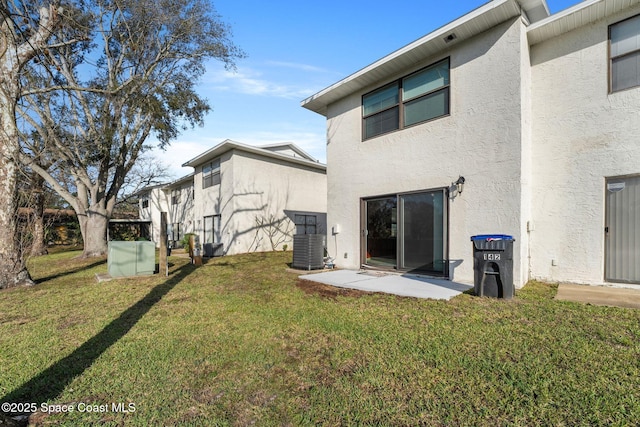 back of house with central AC unit, a patio area, and a lawn