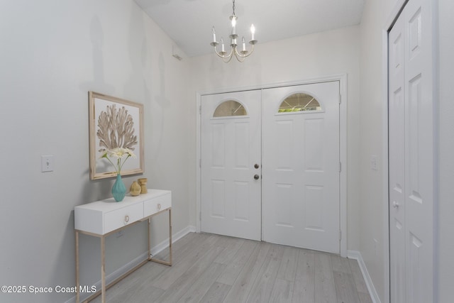 entryway with light hardwood / wood-style flooring and a notable chandelier