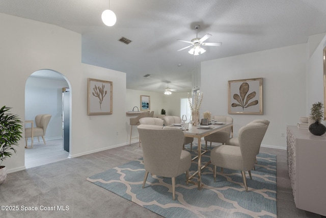 carpeted dining area featuring a textured ceiling and ceiling fan