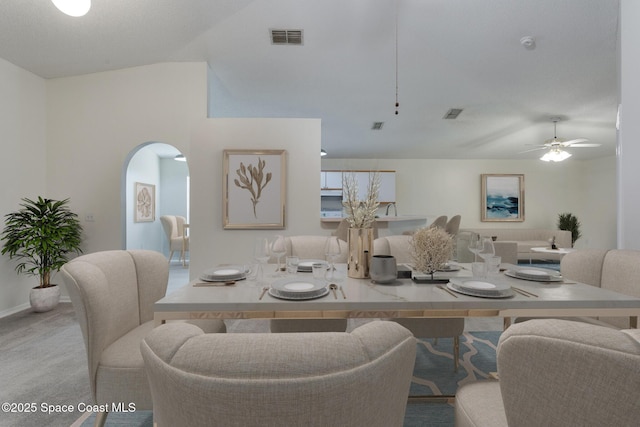 dining room with light carpet, vaulted ceiling, and ceiling fan