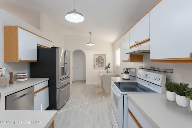 kitchen featuring appliances with stainless steel finishes, light wood-type flooring, vaulted ceiling, white cabinets, and hanging light fixtures