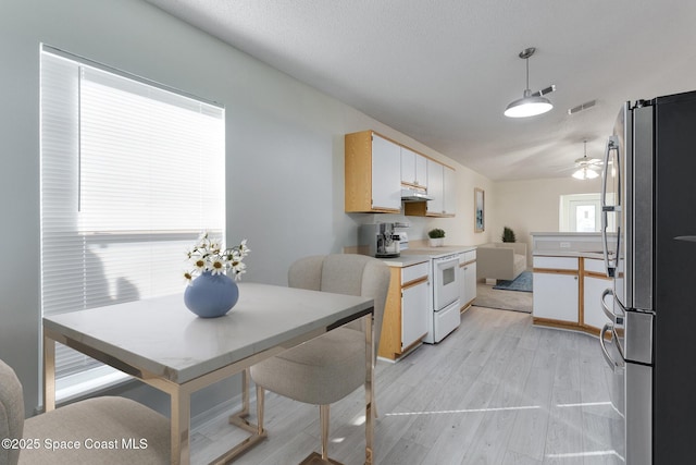 kitchen with stainless steel fridge, ceiling fan, electric stove, white cabinets, and hanging light fixtures