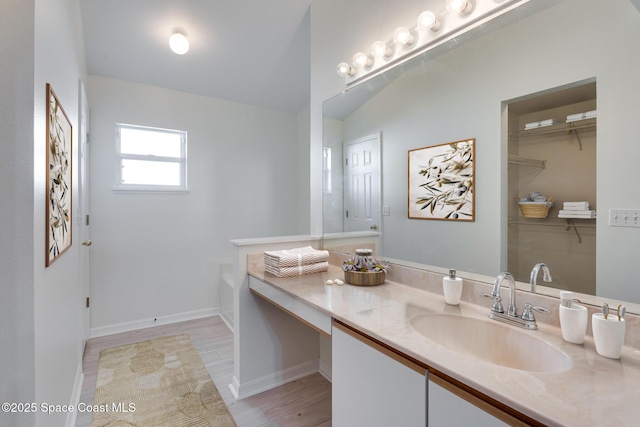 bathroom featuring wood-type flooring, vanity, and a tub