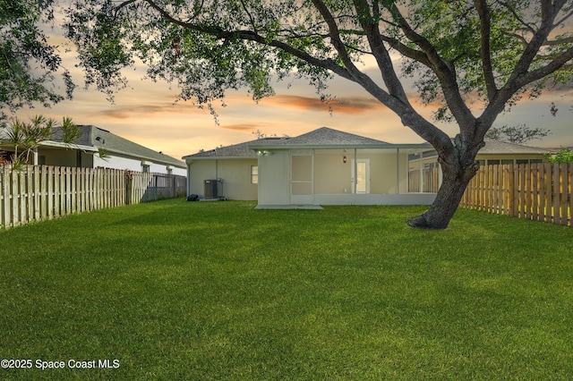 back house at dusk with a lawn