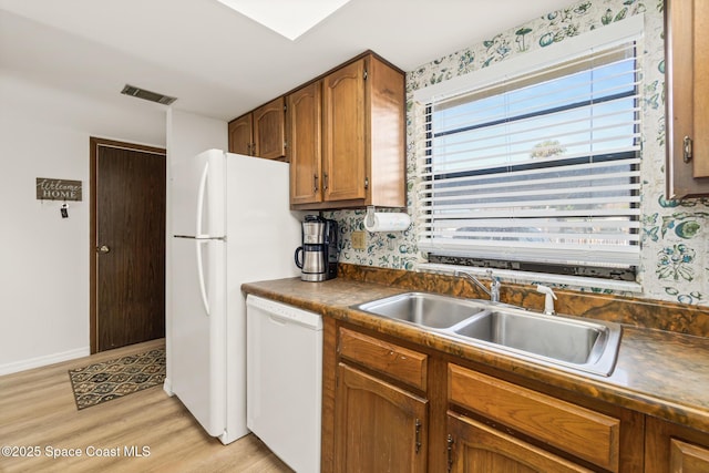 kitchen with dishwasher, light hardwood / wood-style floors, and sink