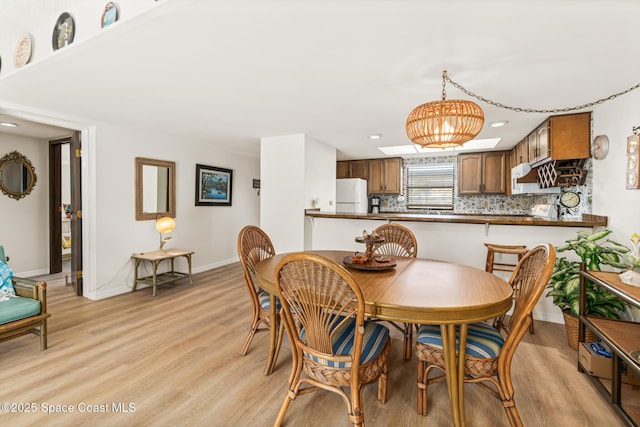 dining space featuring light hardwood / wood-style floors and a notable chandelier