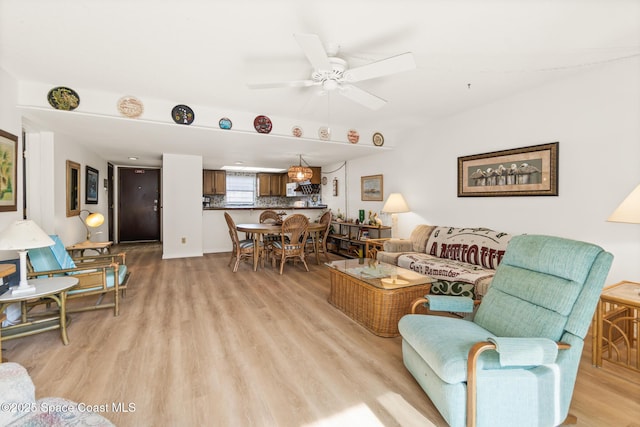 living room with ceiling fan and light hardwood / wood-style flooring