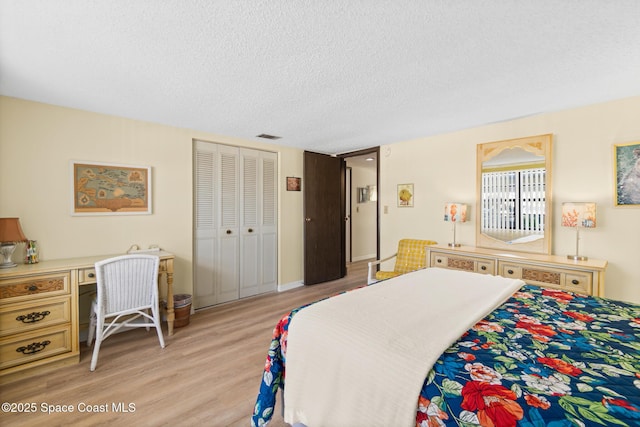 bedroom featuring a textured ceiling, light wood-type flooring, and a closet