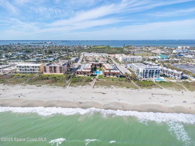 drone / aerial view featuring a beach view and a water view