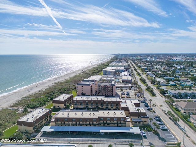 birds eye view of property with a water view and a beach view